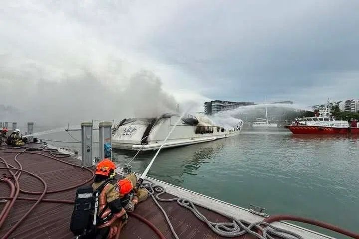 SCDF firefighters deploying a water jet from a pontoon at the ONE°15 Marina Club to fight a fire on a yacht on the morning of June 7. - Photo: SINGAPORE CIVIL DEFENCE FORCE/FACEBOOK