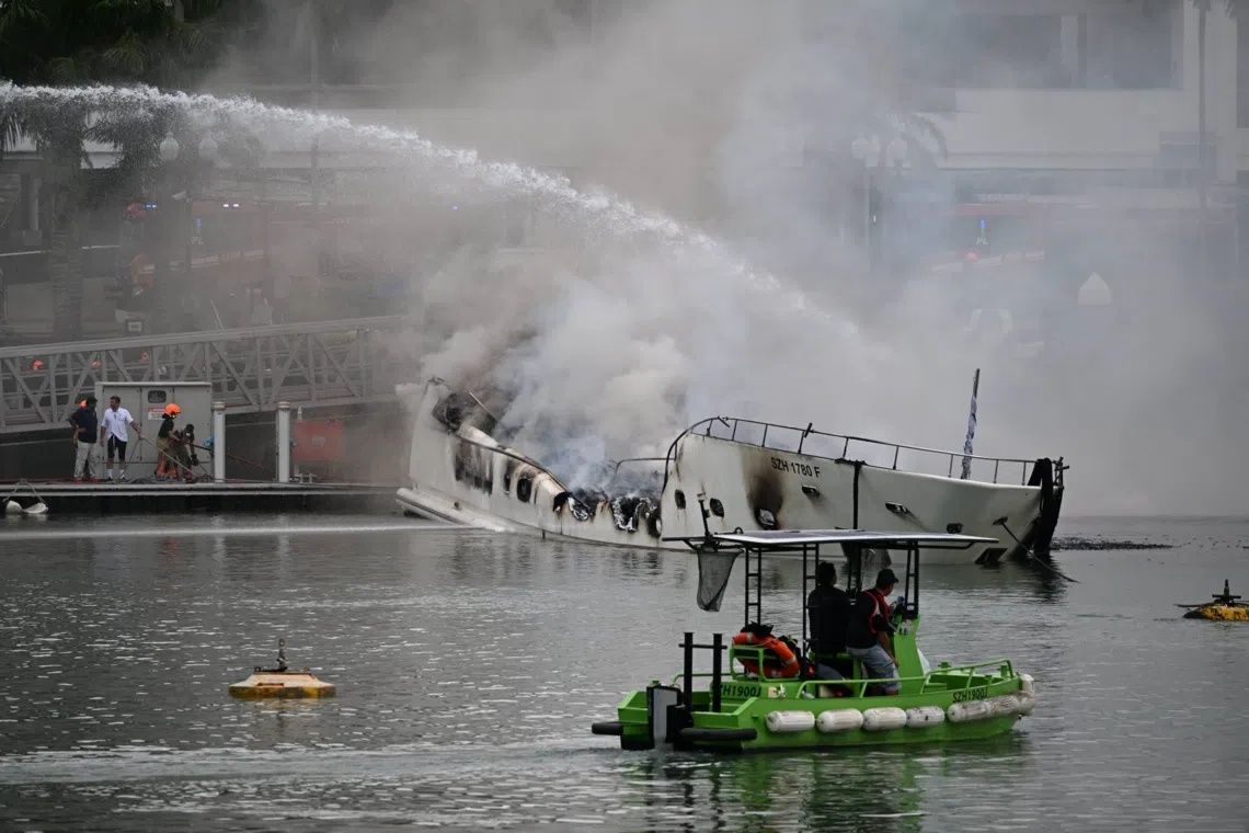 Firefighters continued to apply water and damp down the yacht, says SCDF. -- ST PHOTO: AZMI ATHNI