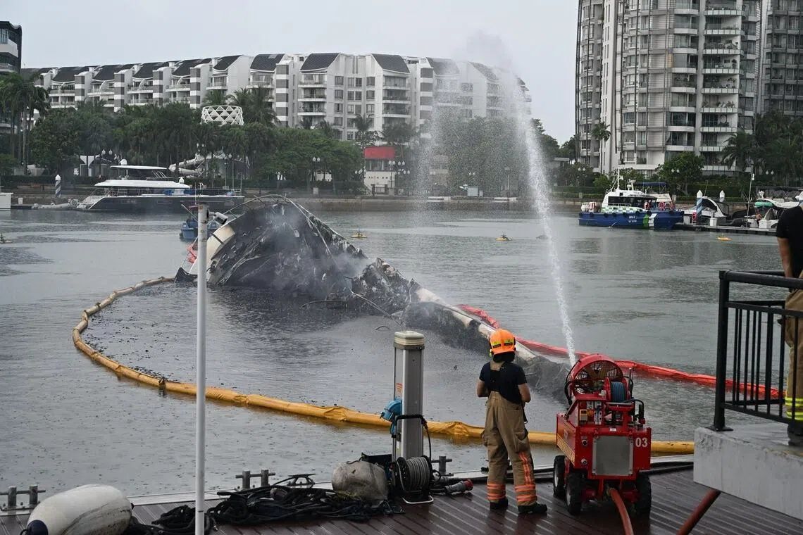 A large portion of the yacht sank into the water at about 2pm, hours after the fire on the boat first started. -- ST PHOTO: AZMI ATHNI