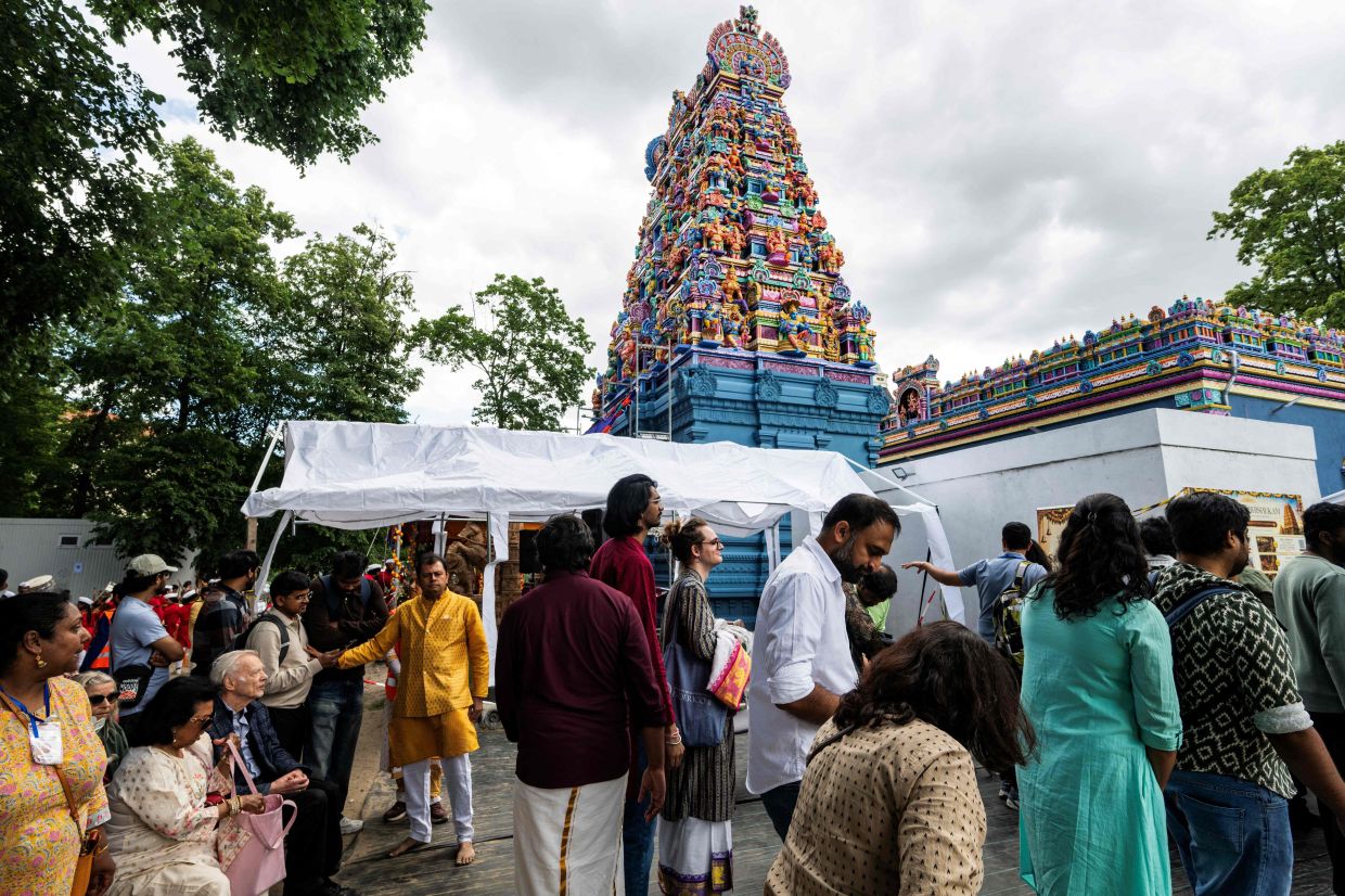 Hindu devotees queue up before entering the newly inaugurated Sri Ganesha Temple in Berlin on Sunday, June 7, 2026. The Hindu temple, dedicated to the Hindu deity Ganesha and built in South Indian Dravidian style, was consecrated on June 7 after more than two decades of planning and construction, at Hasenheide in Berlin's Neukoelln district. With its tower of over 17 metres of height, it is said to be the largest Hindu temple in Germany. The construction costs of more than one million euros were financed by donations. -- Photo by John MACDOUGALL / AFP