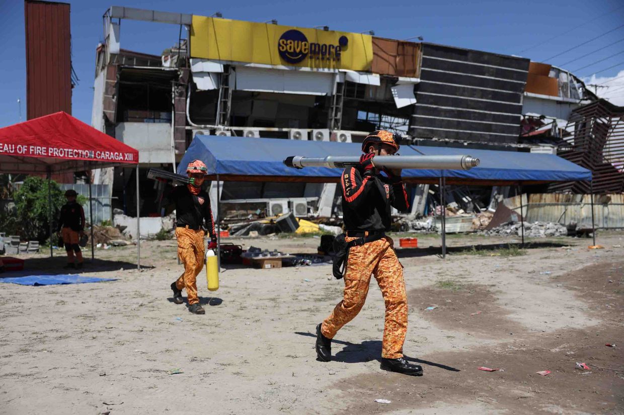 Rescuers preparing their equipment for a search operation at a damaged building following an earthquake in General Santos, Philippines on June 9, 2026. - AP