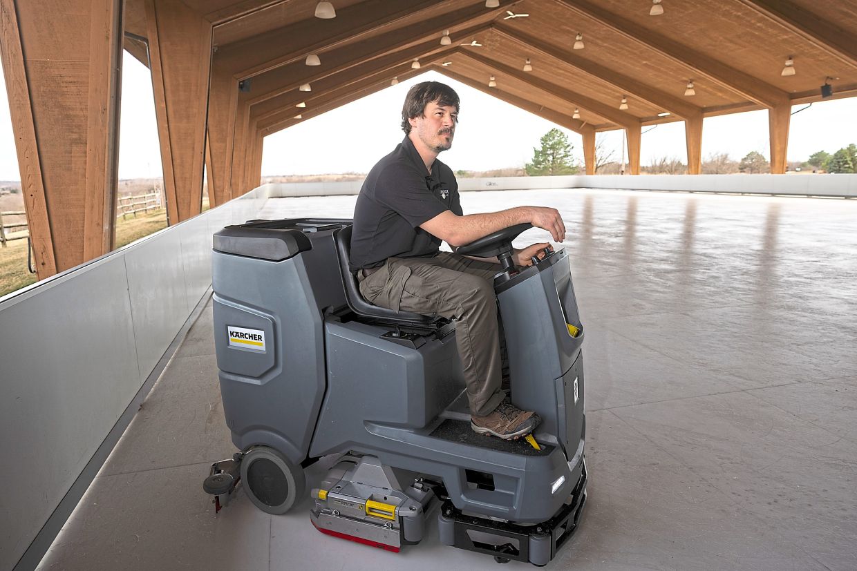 Townsend driving a floor scrubber to clean and smooth the synthetic ice rink surface at Mahoney State Park in Ashland, Nebraska. — Rebecca Gratz/The New York Times
