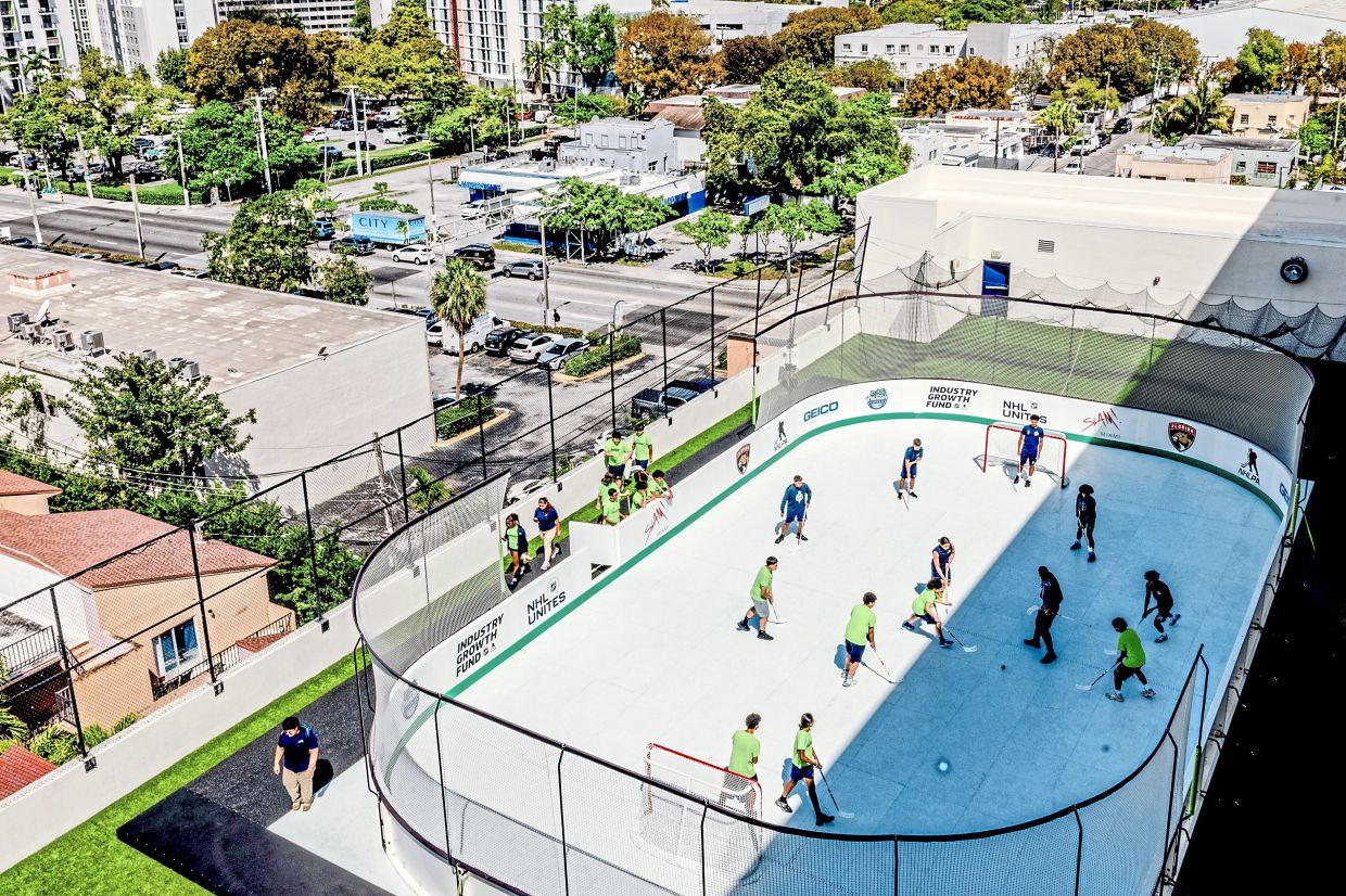 Students learning to play hockey on a synthetic ice hockey rink at Slam Miami, a charter school in the Little Havana neighbourhood of Miami. Hockey rinks are turning to plastic ice as the planet warms; some environmentalists question using plastic to address rising temperatures. — Scott McIntyre/The New York Times