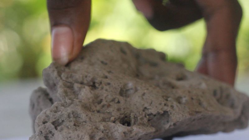 Images show brown pumice ‌rock lines the island's coast, in 