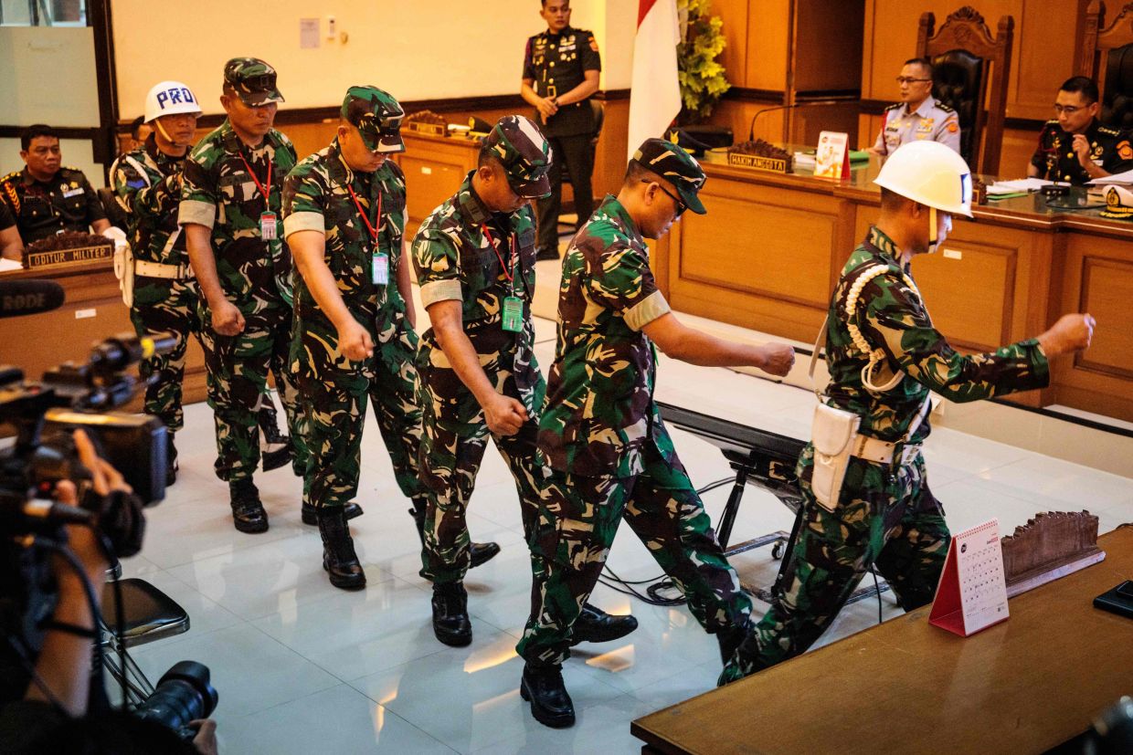 Four Indonesian military personnel accused of throwing acid at a human rights activist leaving after a verdict hearing at a military court in Jakarta on June 10, 2026. The court sentenced the four soldiers to up to three years in prison for an acid attack on an activist critical of perceived militarisation of the government. - AFP