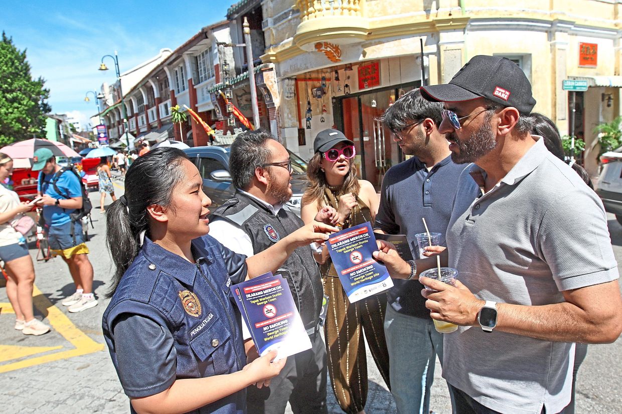 MBPP enforcement officers handing out flyers on Penang’s smoke-free policy.