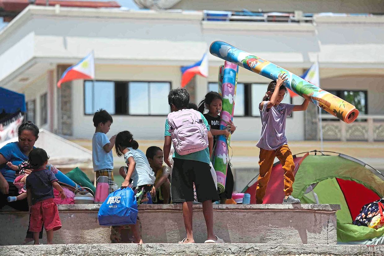Taking no chances: Residents seeking shelter in a square outside a municipal hall in Sarangani province. More than 25,000 people remain displaced, many staying in government-run emergency shelters and still too traumatised to return home. — AP