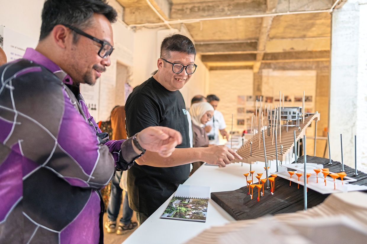 Beh (right) presenting his model of durian catcher canopies at a durian orchard visitor centre. Photo: Tirta Winata