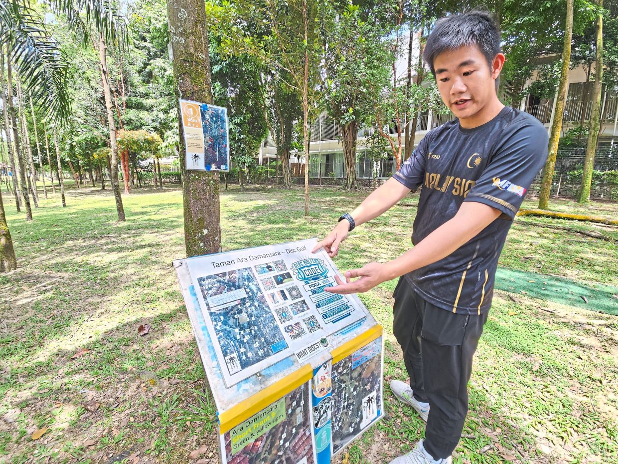 Loh pointing out information for beginners at Ara Damansara park, including the course layout, etiquette and player resources.