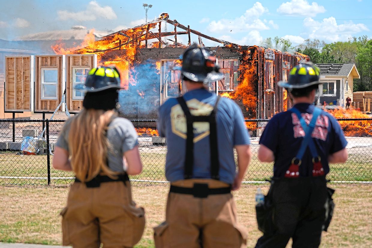 Chester County firefighters (from left) Elizabeth Stevenson, Michael Mackey and Charles Lee watch an accessory dwelling unit burn during an experiment.