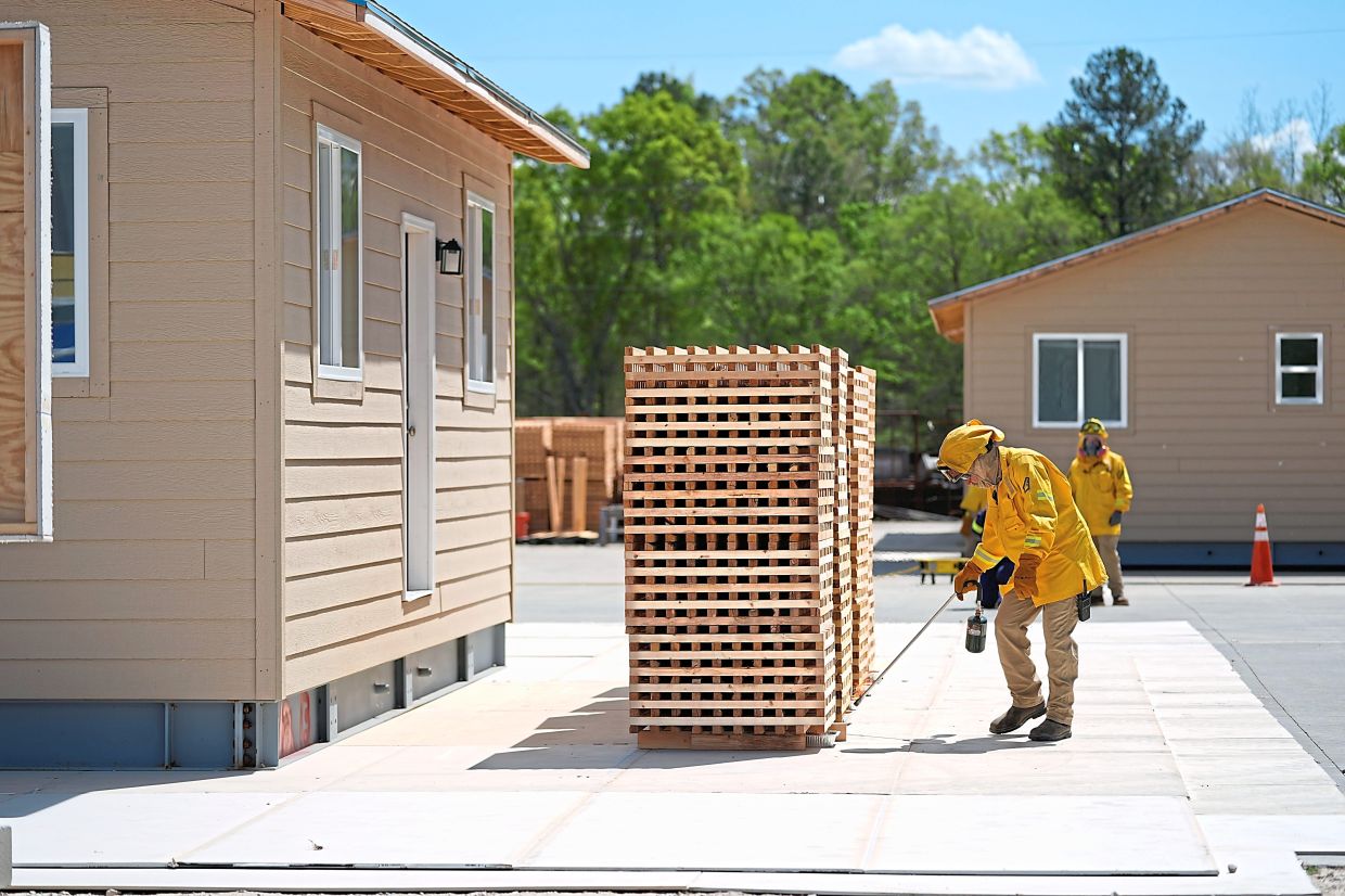 Lead carpenter David Trull ignites wood cribs for an accessory dwelling unit burn experiment.