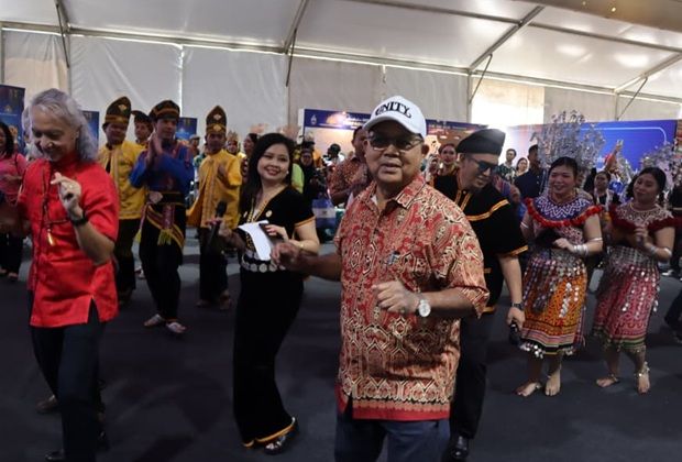 National Unity Minister Datuk Seri Aaron Ago Dagang joins participants in a cultural performance.