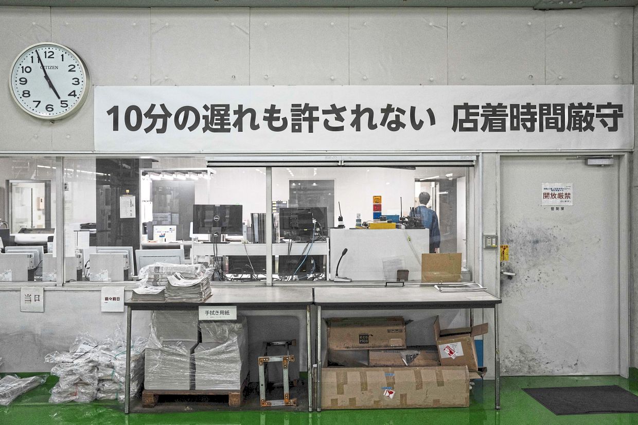 A notice reading: 'Even a 10-minute delay is unacceptable. Arrival times must be strictly observed' at the Kyoto Shimbun factory. Photo: AFP