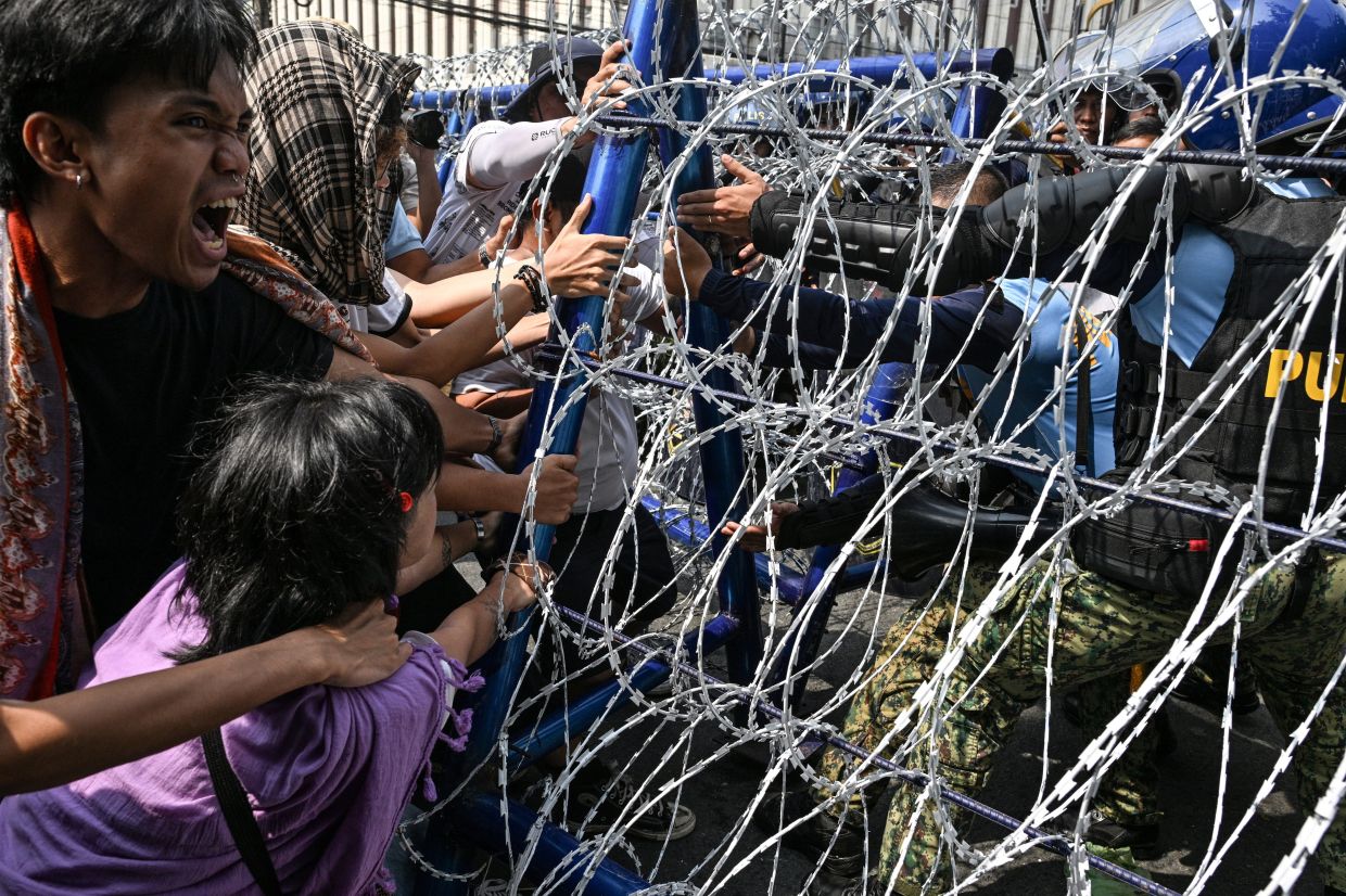 Protesters scuffle with policemen as they try to remove barricades while marching towards the U.S. Embassy to commemorate the 128th Independence Day in Manila, Philippines. -- Photo: REUTERS/Noel Celis