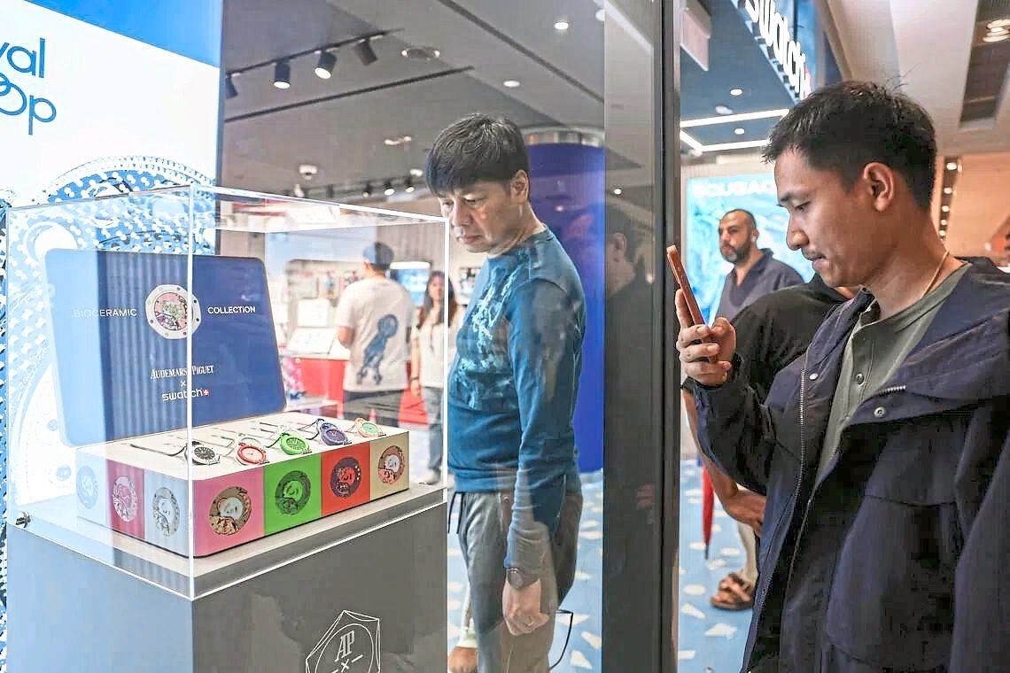 Shoppers in a Singapore malllooking at the Royal Pop collection. — Photo: The Straits Times/Brian Teo