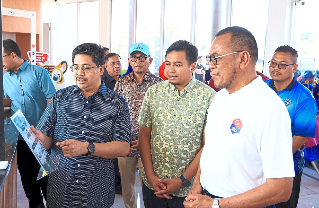 (From left) Hasrin Kamal, Mohammad Nazrul and Kota Iskandar assemblyman Datuk Pandak Ahmad visiting the information centre at the Kampung Sungai Melayu jetty. — Handout