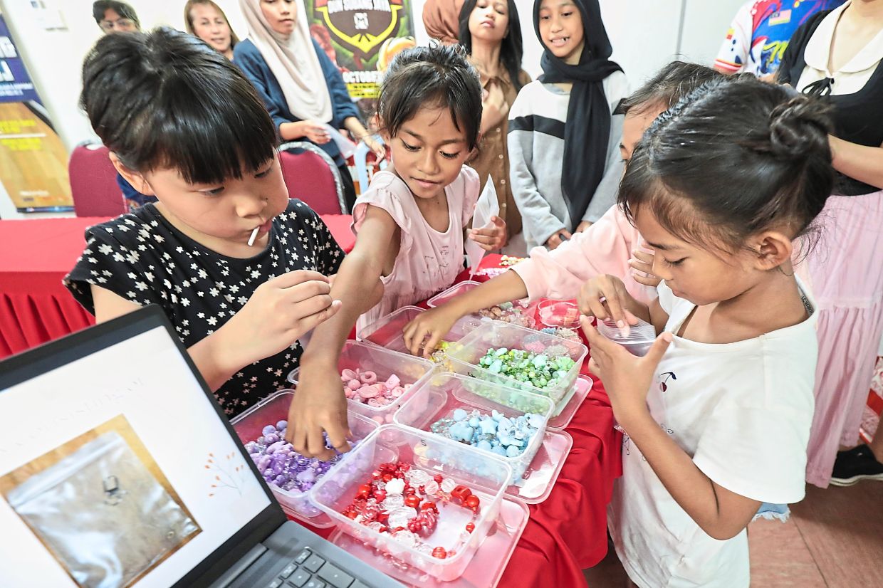Youngsters happily taking part in the keychain-making activity organised by My SJ Club for Mothers Day. — YAP CHEE HONG/The Star