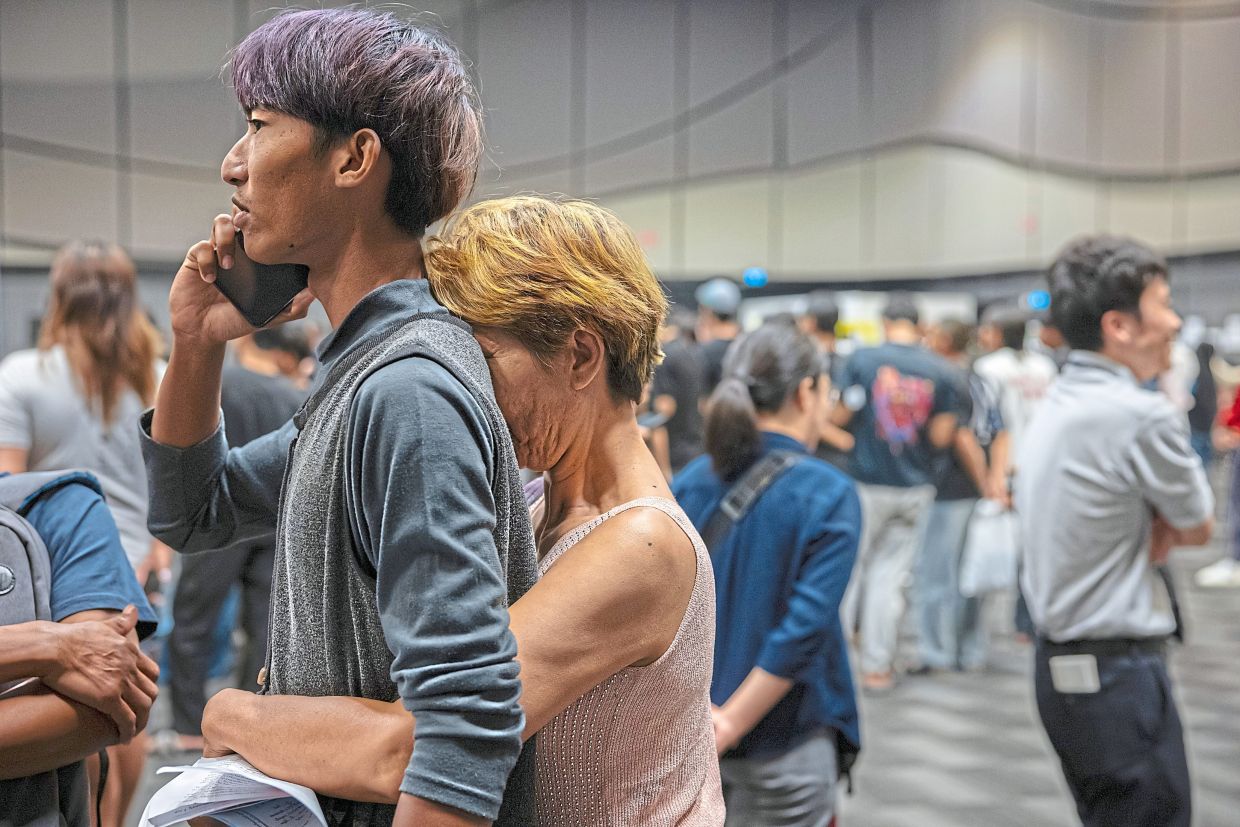 Patchaya, seen with his mother, drew a red card in Nonthaburi. — Lauren DeCicca/The New York Times