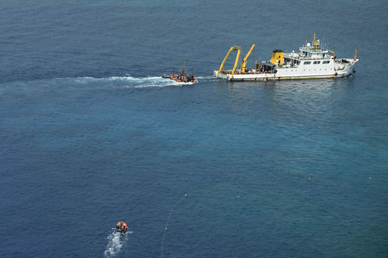 A ship identified by the Philippine Coast Guard as a Chinese research vessel is seen towing a floating structure at Scarborough Shoal in the disputed South China Sea on Monday, June 15, 2026. - Photo by Jam STA ROSA / AFP