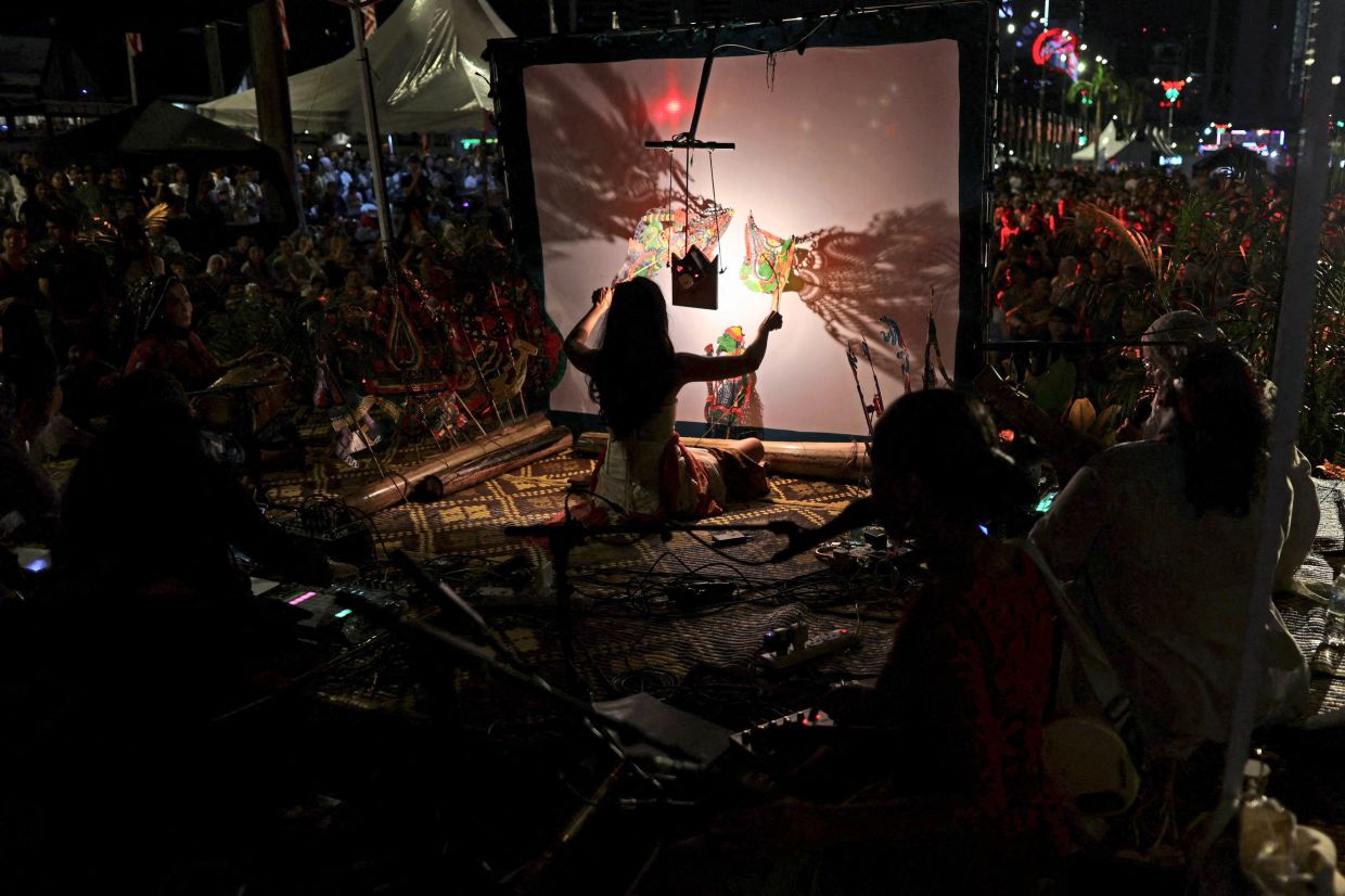 Sumanto captivating the audience as she manipulates puppets between light and screen, bringing the shadows to life. — Reuters