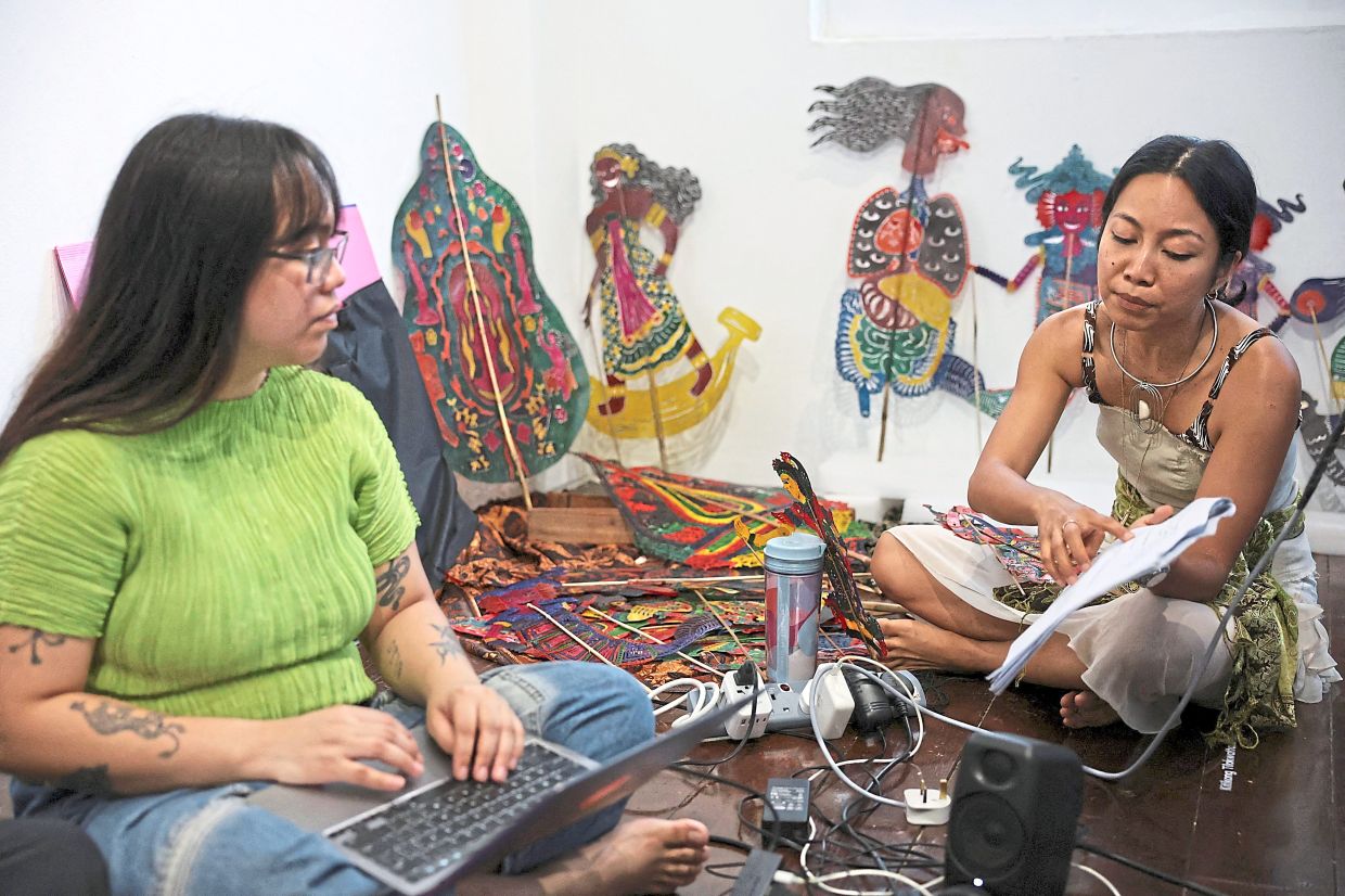 Malaysian music producer Victoria Yam (left) and master puppeteer Illya Sumanto discussing the musical arrangement for their performance, which blends folklore, humour and music from across the region. — Reuters