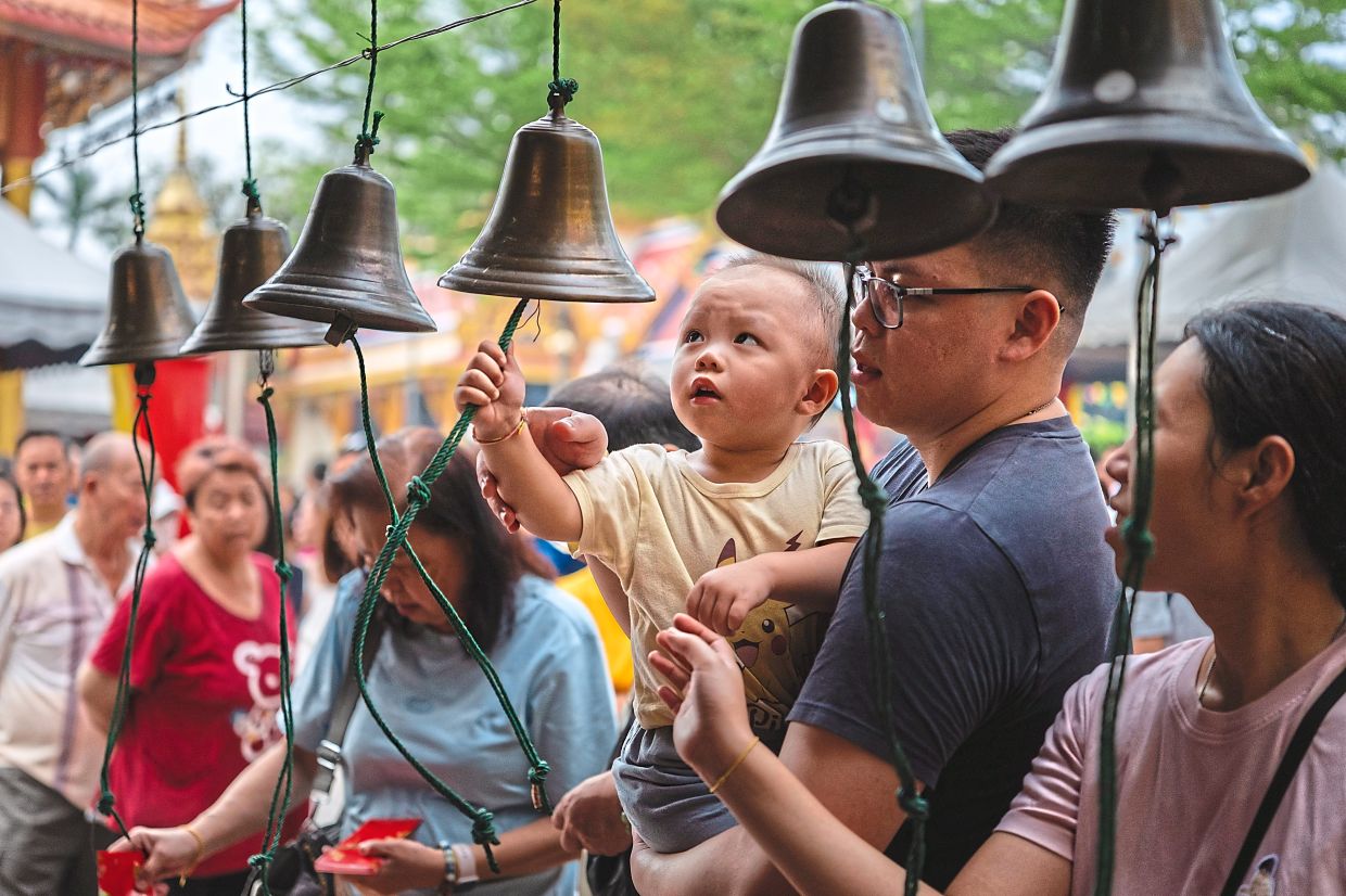 Buddhist devotees gently ringing bells as they take part in Wesak Day prayers at the Thai Buddhist Chetwan Pagoda in Petaling Jaya, Selangor. — Bernama