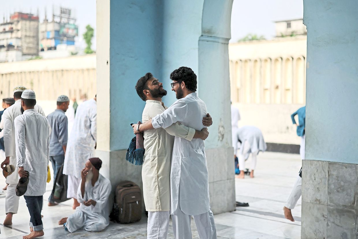 Worshippers embracing after prayers at Baitul Mukarram National Mosque in Dhaka, Bangladesh. — Reuters