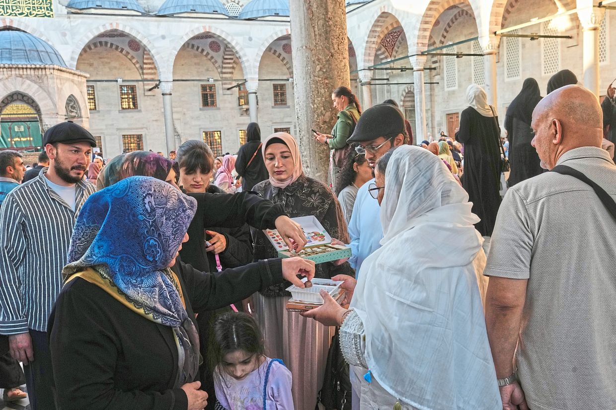 People offering sweets to worshippers on the first day of Aidiladha, the Feast of Sacrifice, marking the end of the annual haj pilgrimage to Mecca and commemorating Prophet Abraham’s willingness to sacrifice his son in obedience to God, at the Ottomanera Sultan Ahmed Mosque in Istanbul, Turkiye. — AP