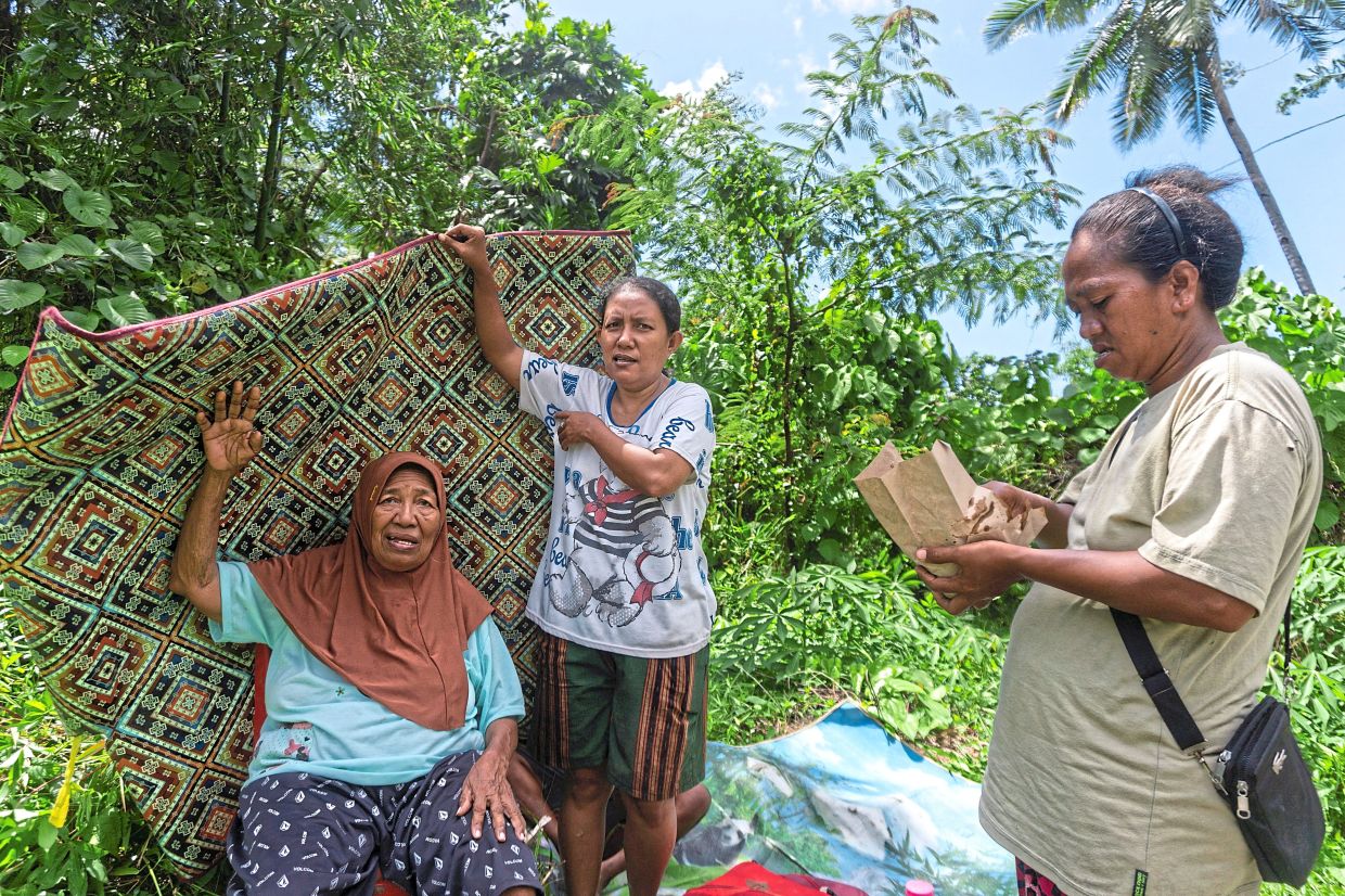 Residents carrying their belongings to safer ground as evacuations unfold after a powerful earthquake struck off the southern Philippine island of Mindanao. — Reuters
