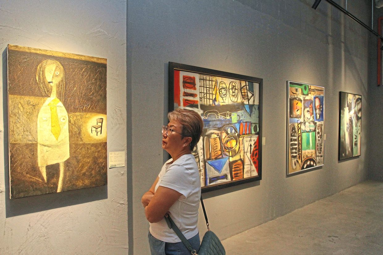 A visitor studying an artwork from Ong’s personal collection at Avantx Art gallery.