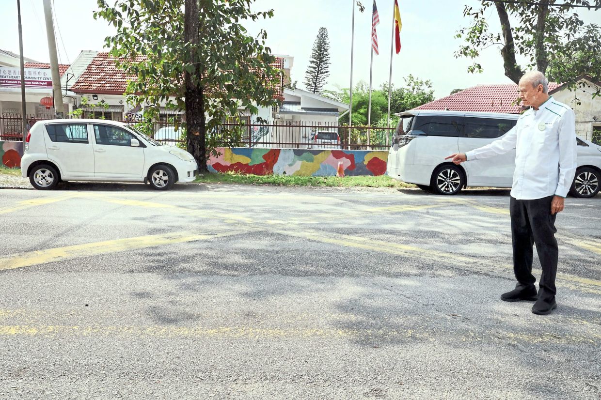 Lee showing some of the faded road markings at Jalan Mengkuang in Klang. — KK SHAM/The Star