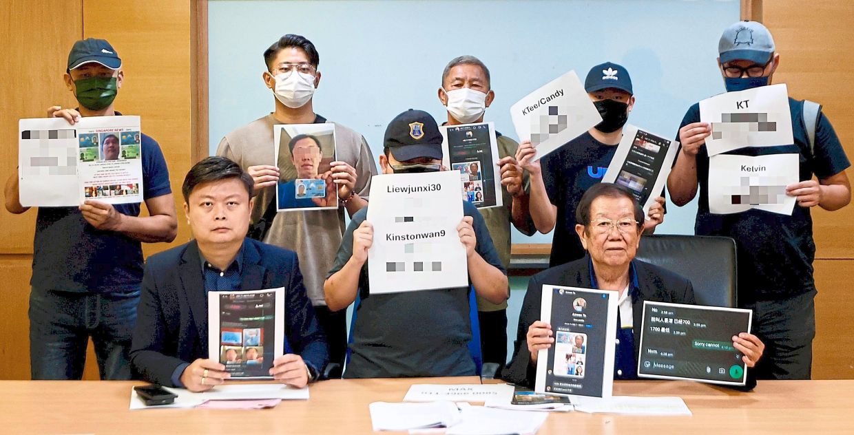 Untangling the web: Michael (right, seated) and Mike (left, seated) showing digital threats by loan sharks at a press conference at Wisma MCA in Kuala Lumpur. — FAIHAN GHANI/The Star