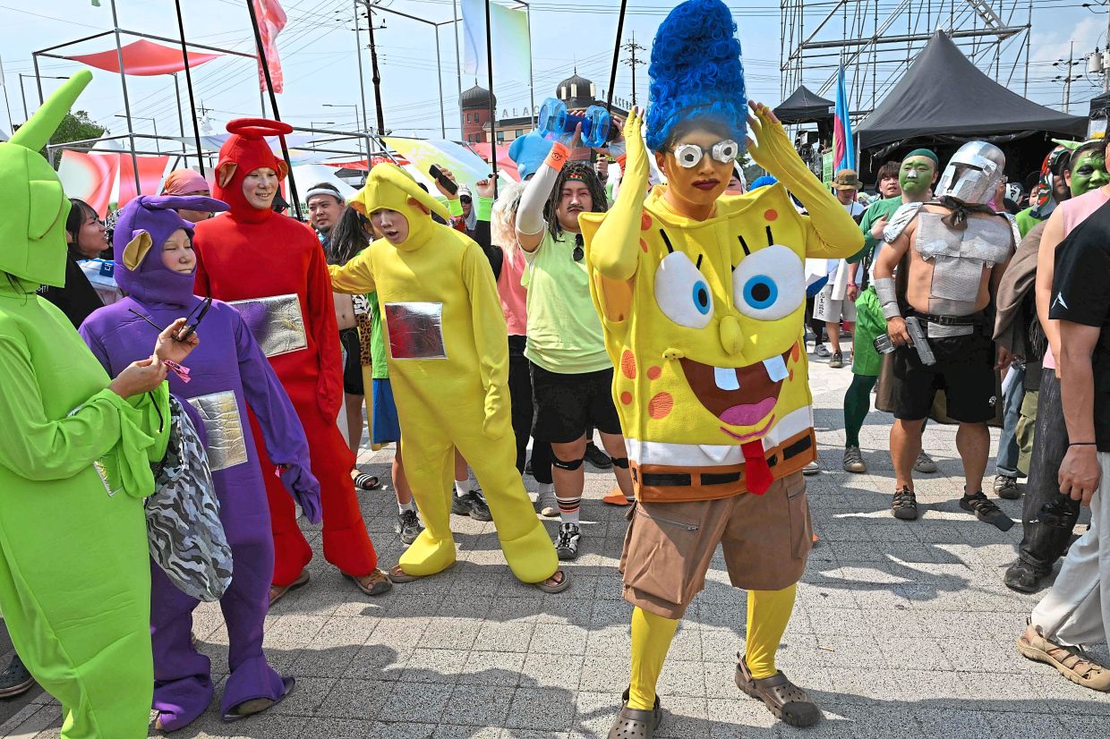 Spreading joy: Festival-goers dressed as iconic characters enjoying themselves during a performance by Peach Truck Hijackers at the DMZ Peace Train Music Festival in Cheorwon. — AFP