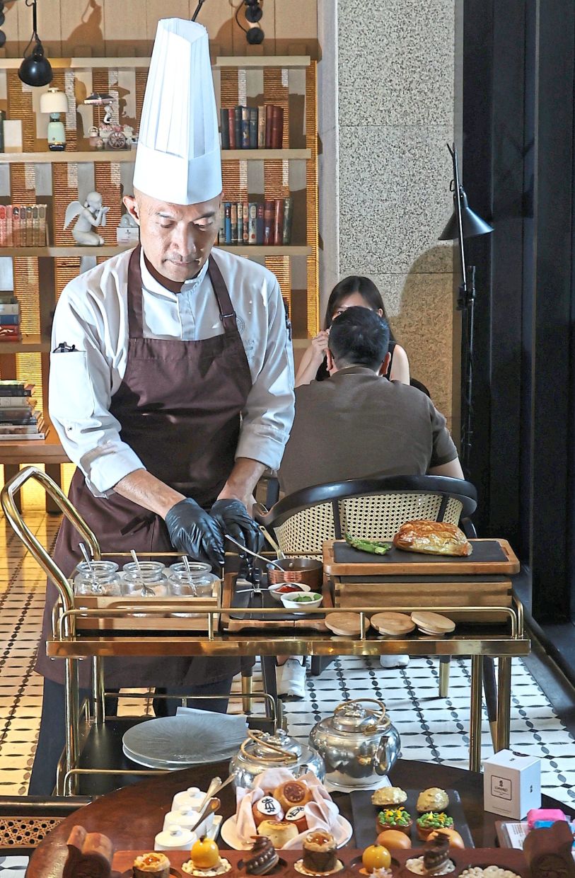 Chef Faizal slicing beef Wellington for diners tableside.