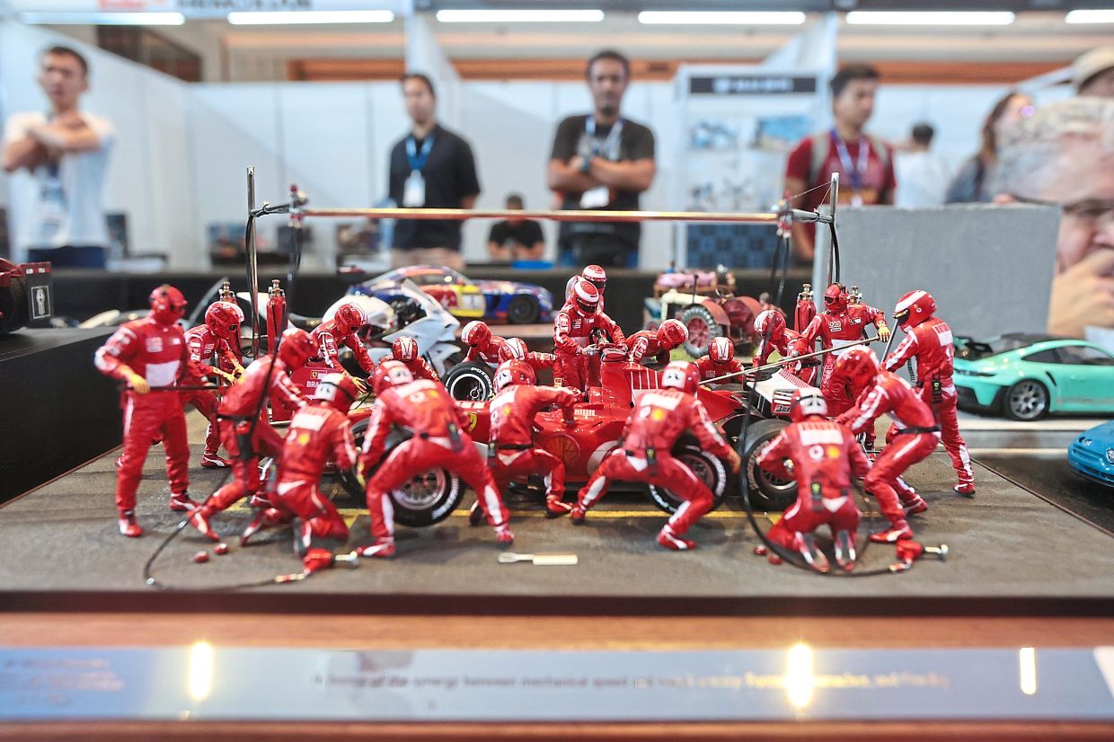 A diorama of a Formula 1 crew racing against time during a pitstop.
