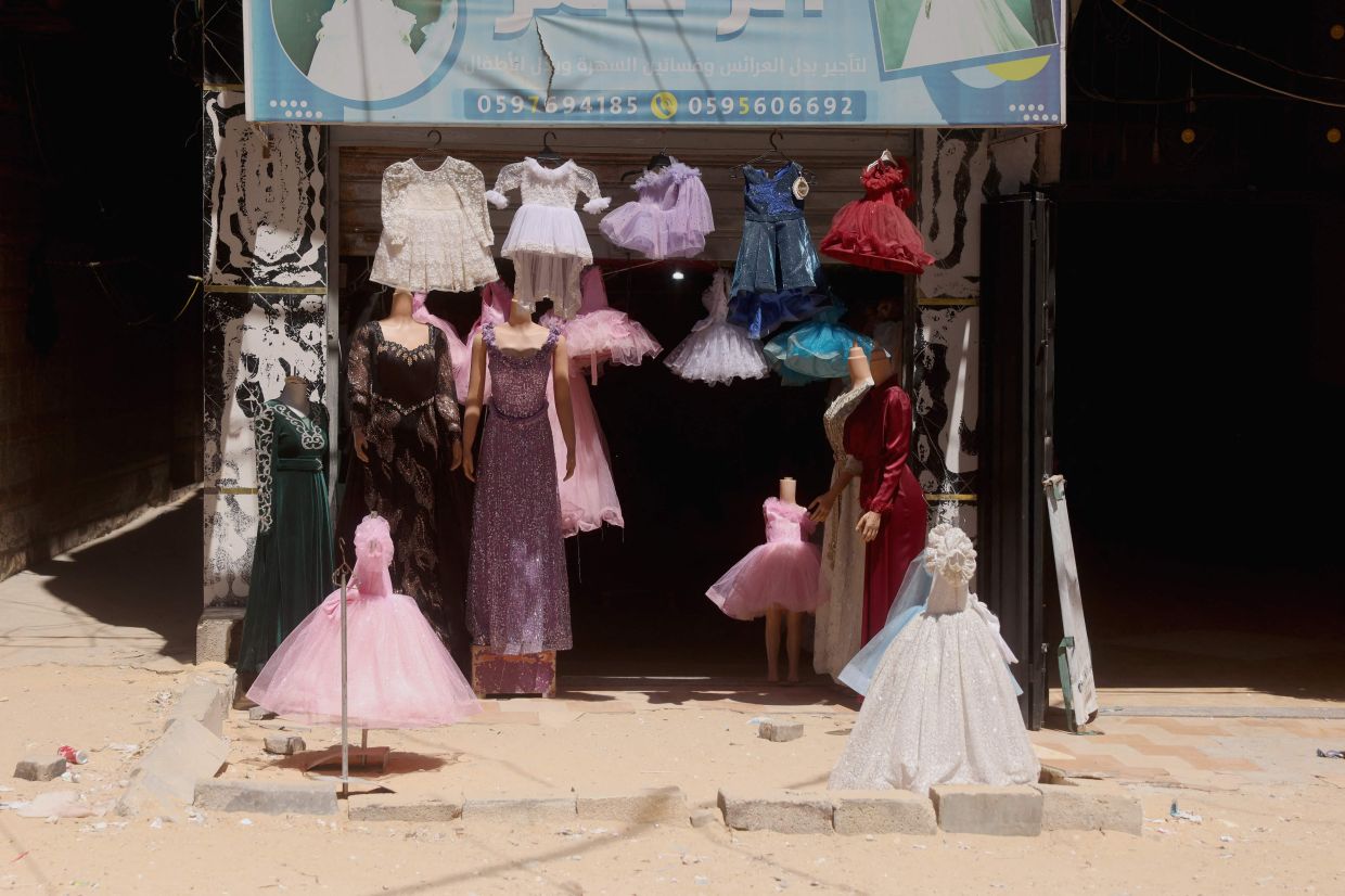Dresses worn for special occasions including weddings are on display outside a shop where they are created despite limited resources and old dresses are recycled. Photo: AFP