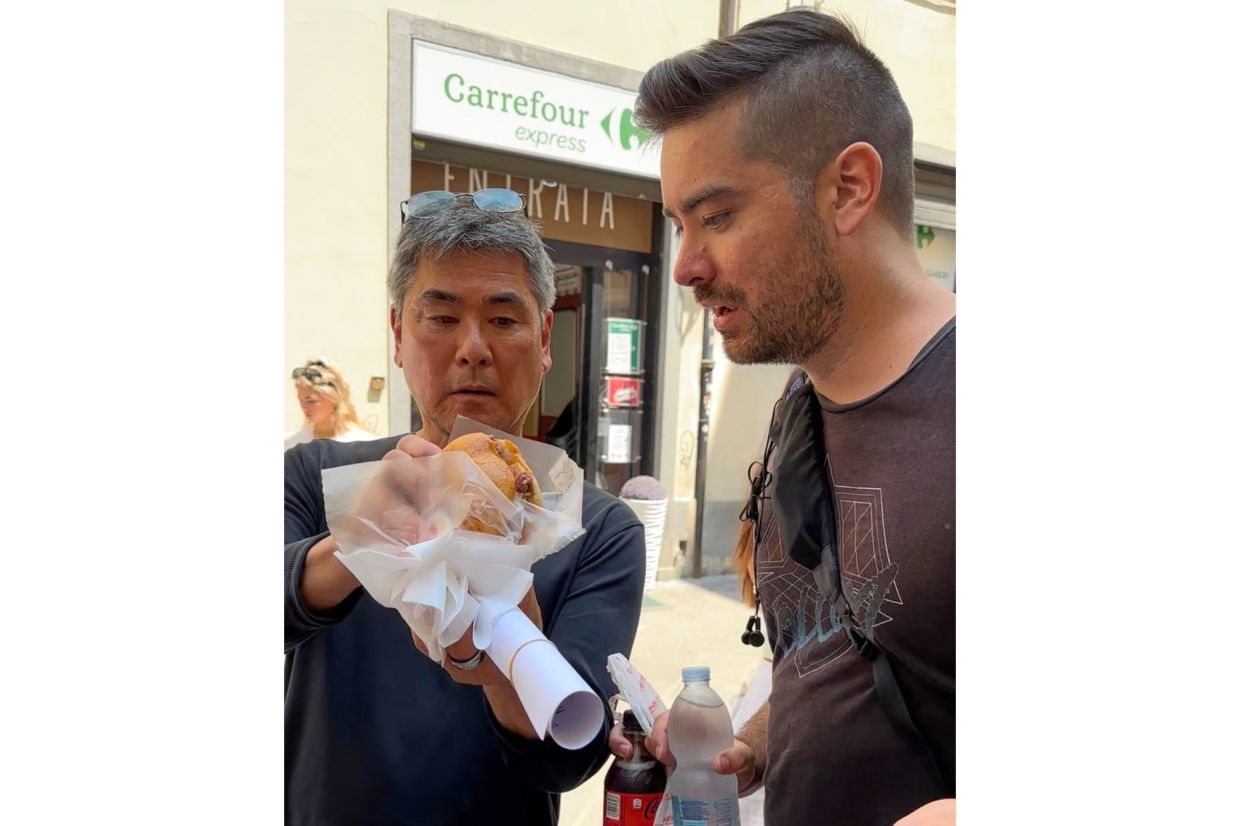 Roy Yamaguchi, founder of Roy’s Restaurants, and his son, Roy Jr., appear with a Lampredotto, a Florentine street food made from slow cooked cow stomach, in Italy. — Photo: Denise Yamaguchi via AP)