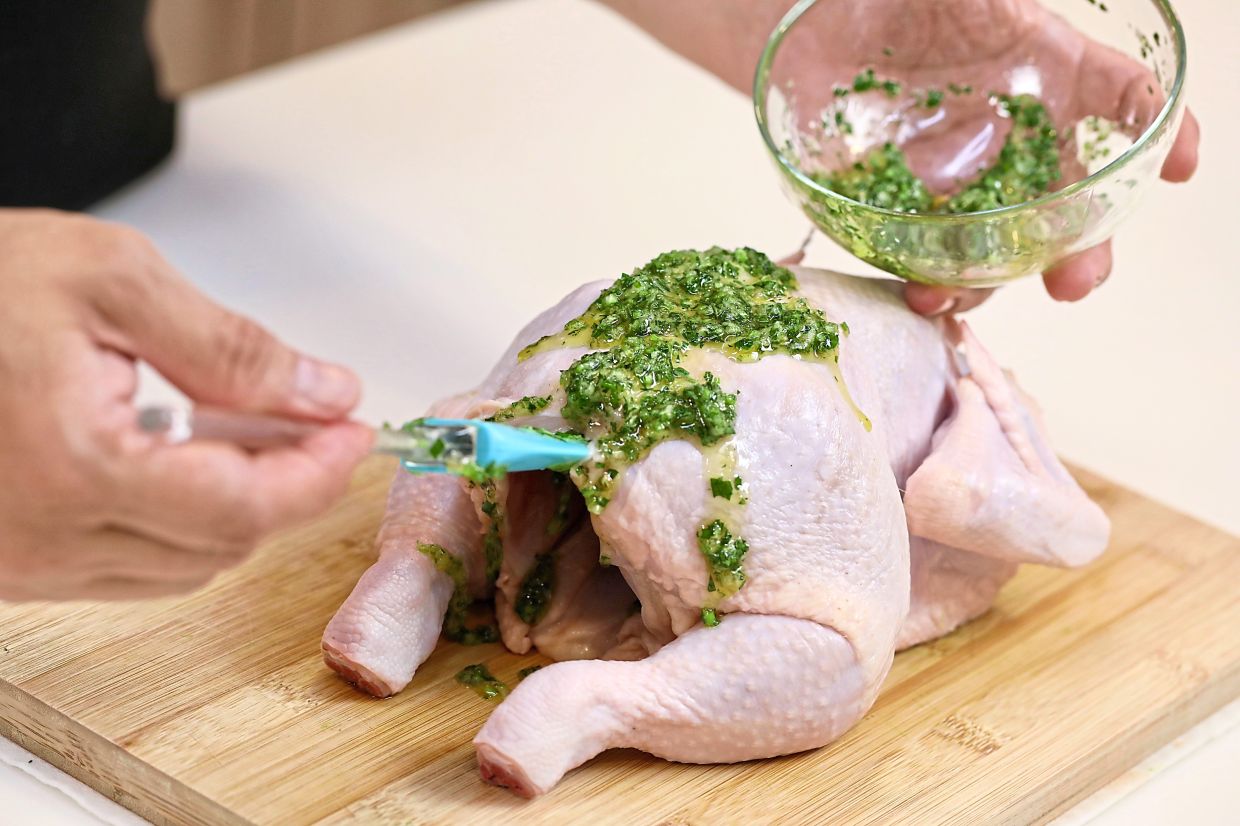 Massage the chicken with a marinade of minced parsley, grated garlic and extra virgin olive oil.