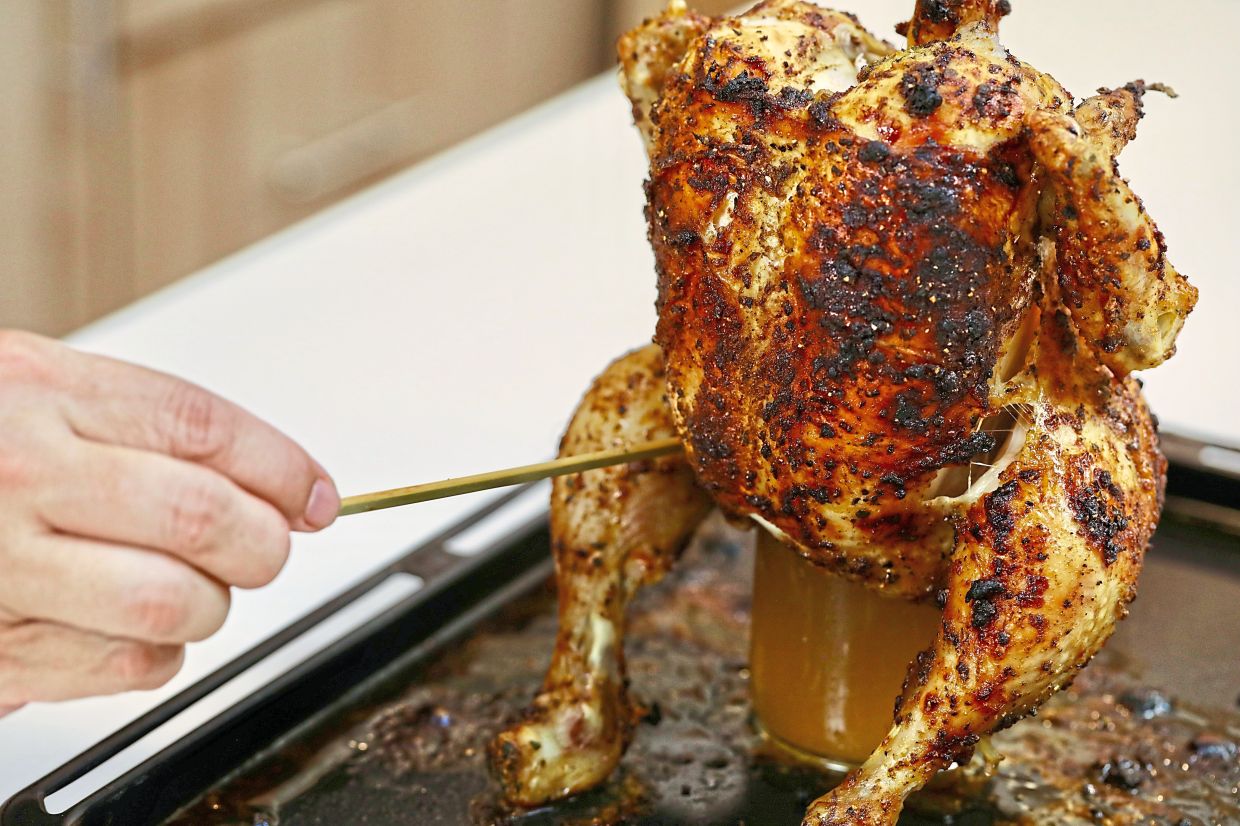 Straddle the chicken upright in the throne of the beer can and roast for about 40-50 minutes until the juice runs clear. — LOW LAY PHON/The Star