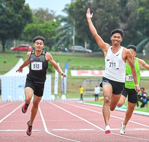 Unstoppable: Perak’s Mohd Azeem Fahmi (right) celebrating after winning the men’s 100m final event during the Malaysian Open. — IZZRAFIQ ALIAS/The Star