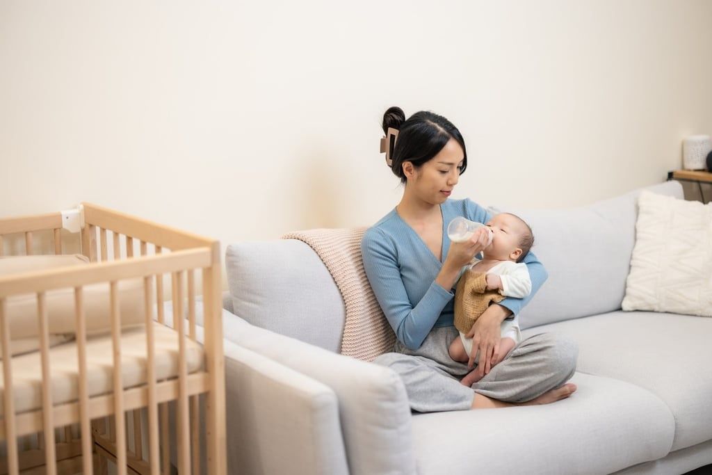 A mother feeds her newborn baby with milk from a bottle at home. - Photo: Shutterstock