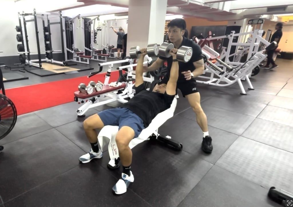 Canlas does overhead presses with his personal trainer, Shamus Sum. - Photo: UP