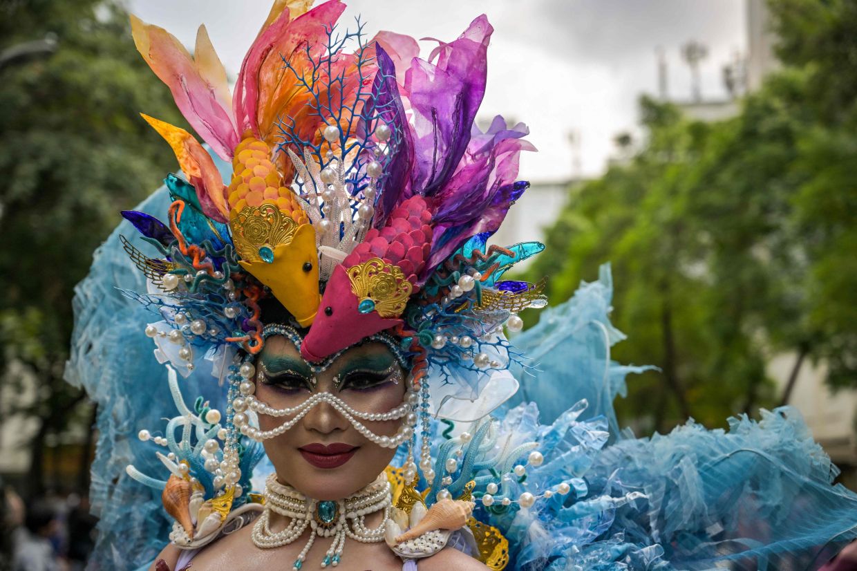 A woman wearing an elaborate costume takes part in the Surabaya Fashion Festival along a street in Surabaya on Sunday, June 21, 2026. -- Photo by JUNI KRISWANTO / AFP