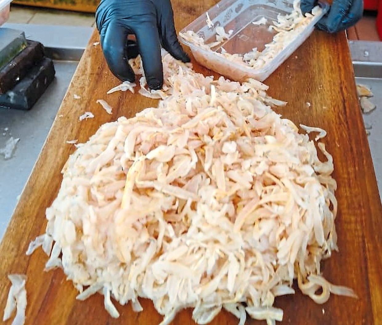 Finely-sliced raw fish being prepared into umai.