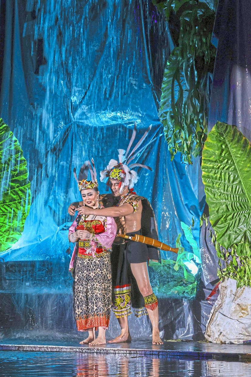 A romantic scene from the musical featuring a waterfall in the background.