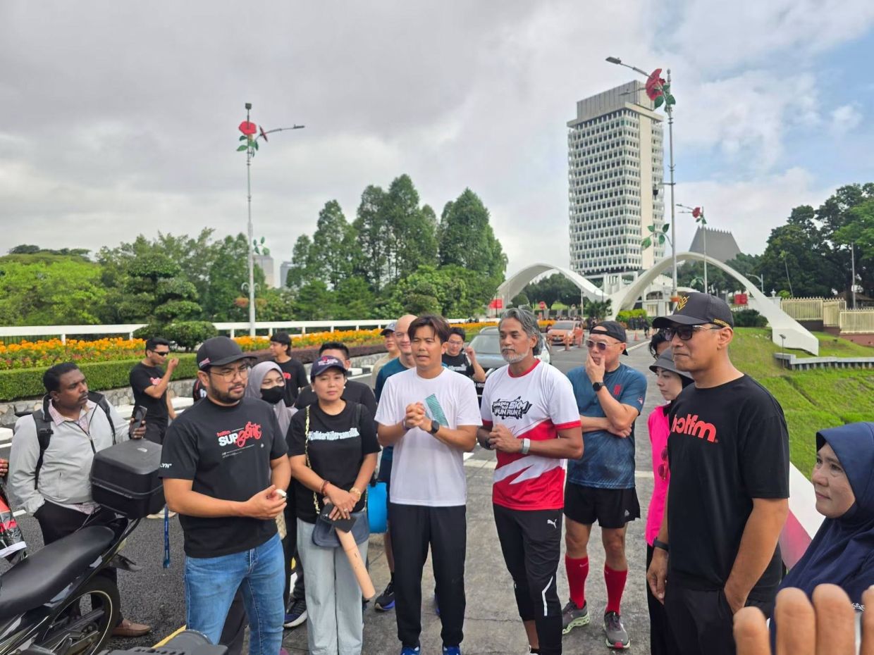 Khairy Jamaluddin (center) and Barisan Nasional Youth community affairs bureau chief Neow Choo Seong with supporters after his run from Taiping to Parliament. Credit: MCA