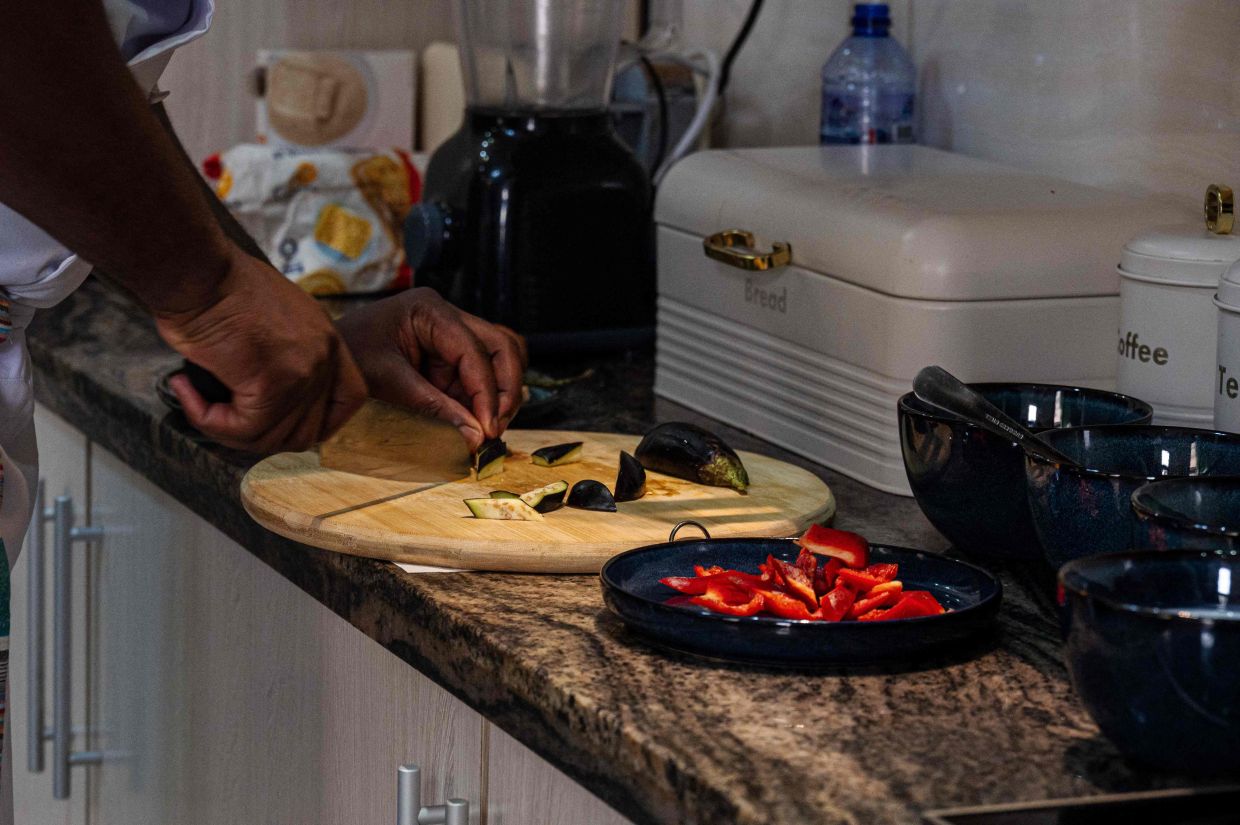 Congolese chef Archi Dimosi prepares ingredients inside his kitchen in Kinshasa.