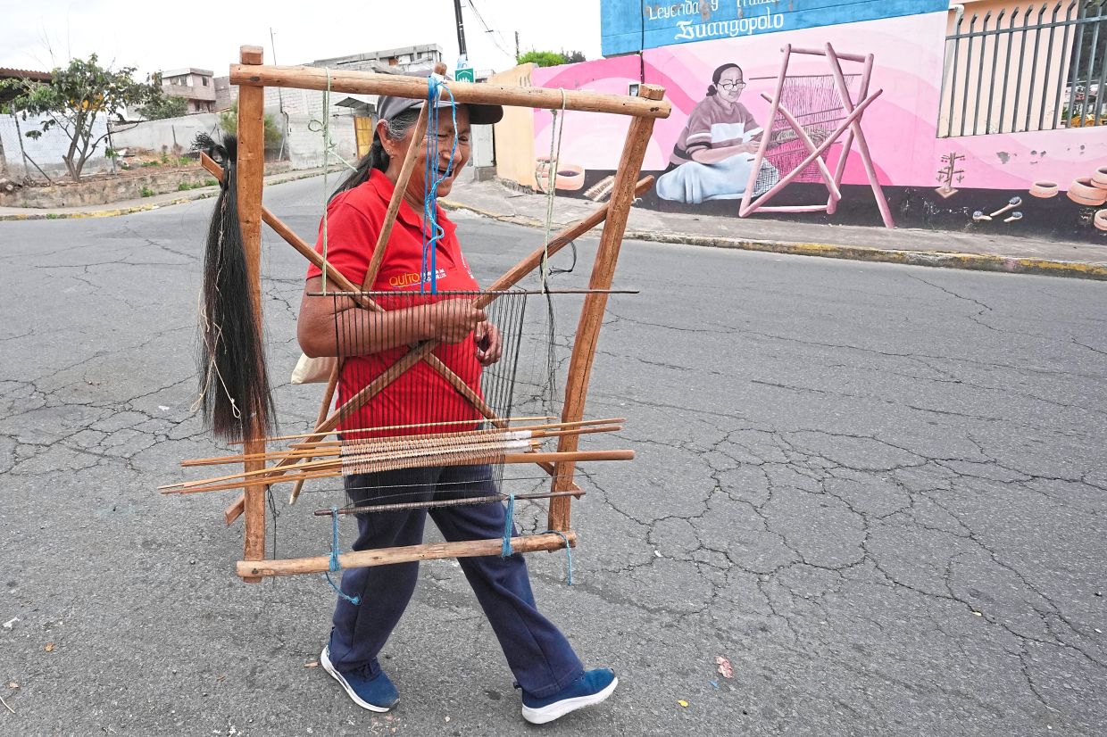 Rosario Legna leaves El Cedacero Artisan Centre carrying her loom.