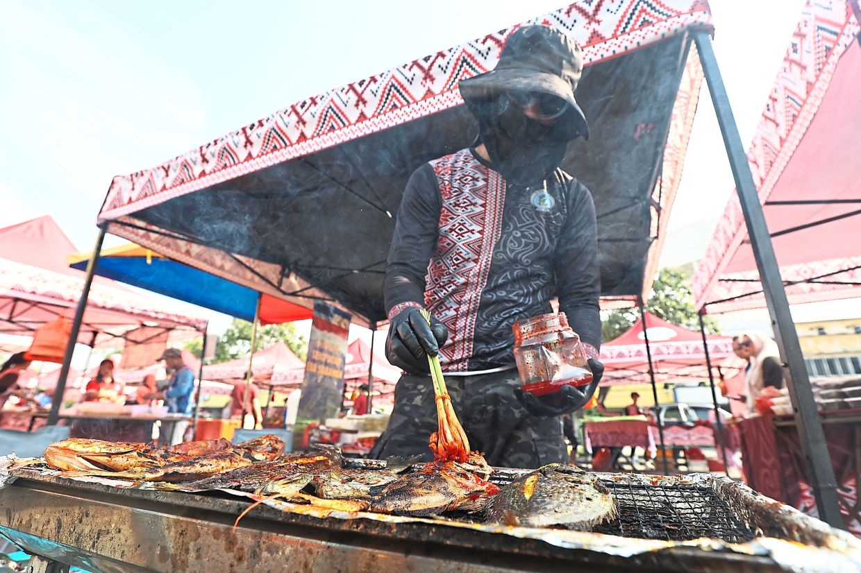 Manan Idanan tending to Sabah-style ‘ikan bakar’ on a grill.