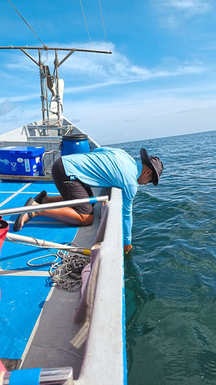 Fong measuring the ocean depth. — ANDREA FILMER/The Star